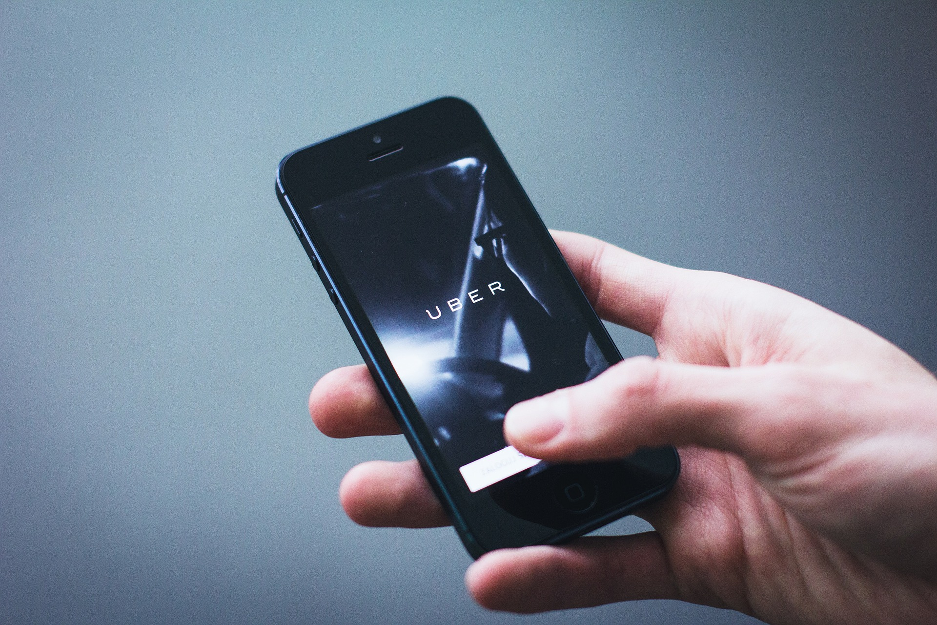 a hand holding the uber app in the phone